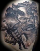 Tatuaje de un demonio agarrando un muñeco de madera