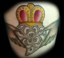 Tatuaje de un corazón con corona, aguantado por dos manos