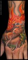 Tatuaje de una bellota envuelta en llamas en la mano