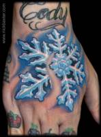 Tatuaje de un copo de nieve en la mano