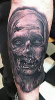Tatuaje de una cara de zombie deshaciendose