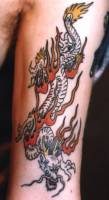 Tatuaje de un dragon bajando por el brazo
