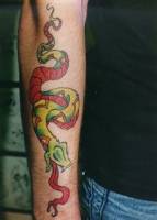 Tatuaje de una serpiente bajando por el brazo