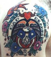 Tatuaje de una águila con la bandera americana entre flores y golondrinas