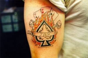Tatuaje de una pica en llamas con algunas cartas