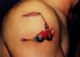 Tatuaje de un coche gracioso corriendo por el hombro