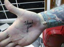 Tatuaje de la letra gracias en la mano