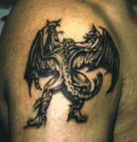 Tatuaje de un dragon demonio escalando por el brazo