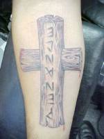 Tatuaje de una cruz de madera en el gemelo