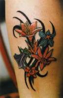 Tatuaje de unas flores saliendo entre un tribal