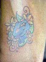 Tatuaje de una ranita saliendo entre unas flores