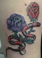 Tatuaje de una serpiente coral pasando entre dos rosas