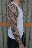 Tatuaje de piel extraterrestre en el brazo