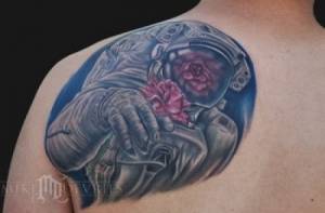 Tatuaje de un astronauta dando una rosa