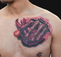Tatuaje de la mano de te sacando el corazón del cuerpo