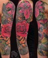 Tatuaje de flores con calaveras disimuladas y un cerrojo