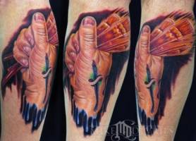 Tatuaje de una mano con varios pinceles