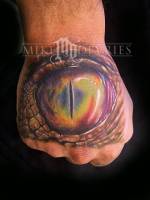 Tatuaje de un ojo reptil en la mano