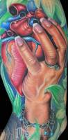 Tatuaje de una mano agarrando un corazón