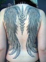 Tatuaje de unas alas enganchadas a la columna