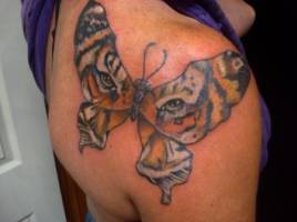 Tatuaje de una forma de mariposa con el fondo de la cara de un tigre