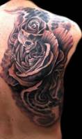 Tatuaje de una rosa con esqueleto dentro