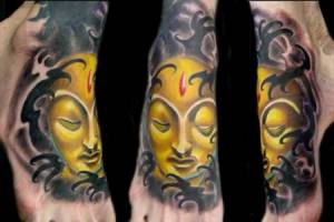 Tatuaje de una cara de Buda dorada entre nubes oscuras