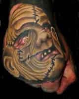 Tatuaje de una cara monstruosa plagada de cicatrices