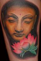 Tatuaje de una cabeza de Buda con flores de loto