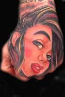 Tatuaje de una cara en la mano