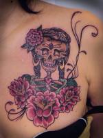 Tatuaje de una calavera con muchas flores y corazones