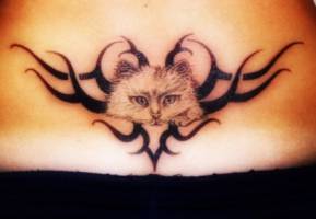 Tatuaje de un tribal con una cara de gato en medio