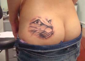 Tatuaje de una cara de gato en el culo