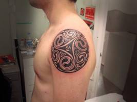 Tatuaje de el simbolo celta del trisquel en el hombro