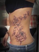 Tatuaje de unas rosas con unas mariposas