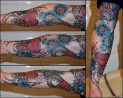 Tatuaje de flores, serpientes y un corazón en el brazo