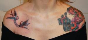 Tatuaje de dos golondrinas, flores, una mariposa y un micrófono