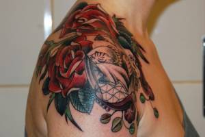 Tatuajes de rosas en el hombro y un tigre blanco escondido entre ellas