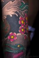 Tatuajes de una serpiente japonesa entre olas y flores