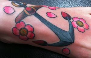 Tatuaje de un ancla con algunas flores