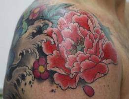 Tatuaje de una flor de loto y olas