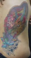 Tatuaje de un dragón agarrando una bola de cristal y una flor