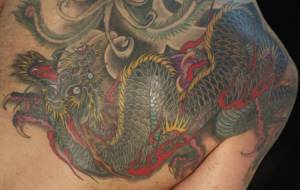 Tatuaje de un dragón japonés en brazo y espalda