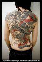 Tatuaje de un gran dragón en la espalda de una mujer