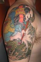 Tatuaje de un samurai matando un dragón