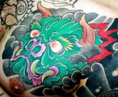 Tatuaje de un demonio japonés asomando la cabeza entre las nubes