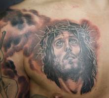 Tatuaje de la cabeza de cristo entre nubes