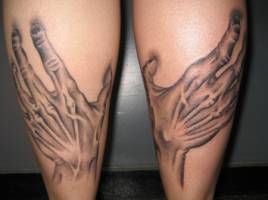 Tatuaje de unas manos agarrando las piernas