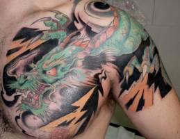 Tatuaje de un dragón entre rayos en brazo y pecho