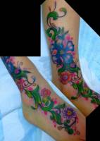 Tatuaje de flores subiendo por la pierna con una mariquita